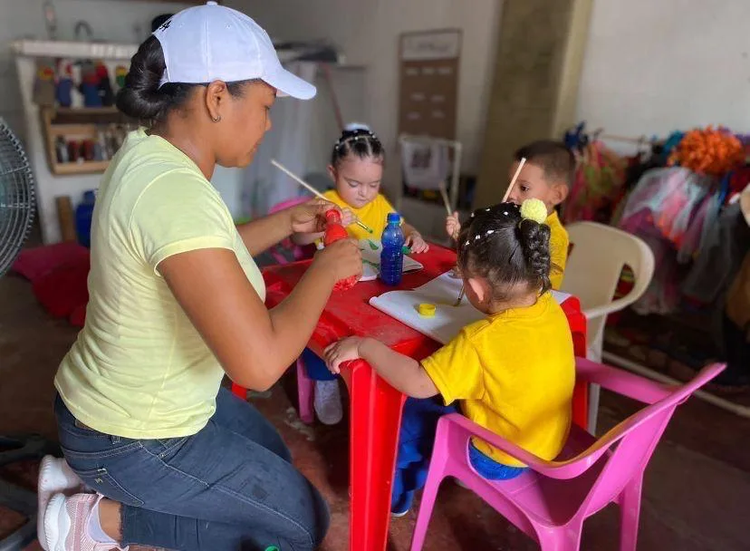 Cuidadora comunitaria acompañando a niños en una actividad